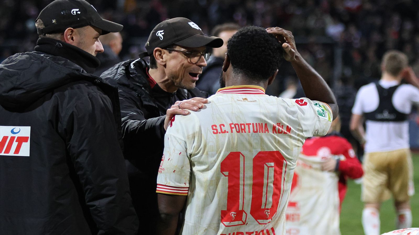 Fortuna Kölns Trainer Matthias Mink im Gespräch mit seinem Offensivspieler Arnold Budimbu (rechts).