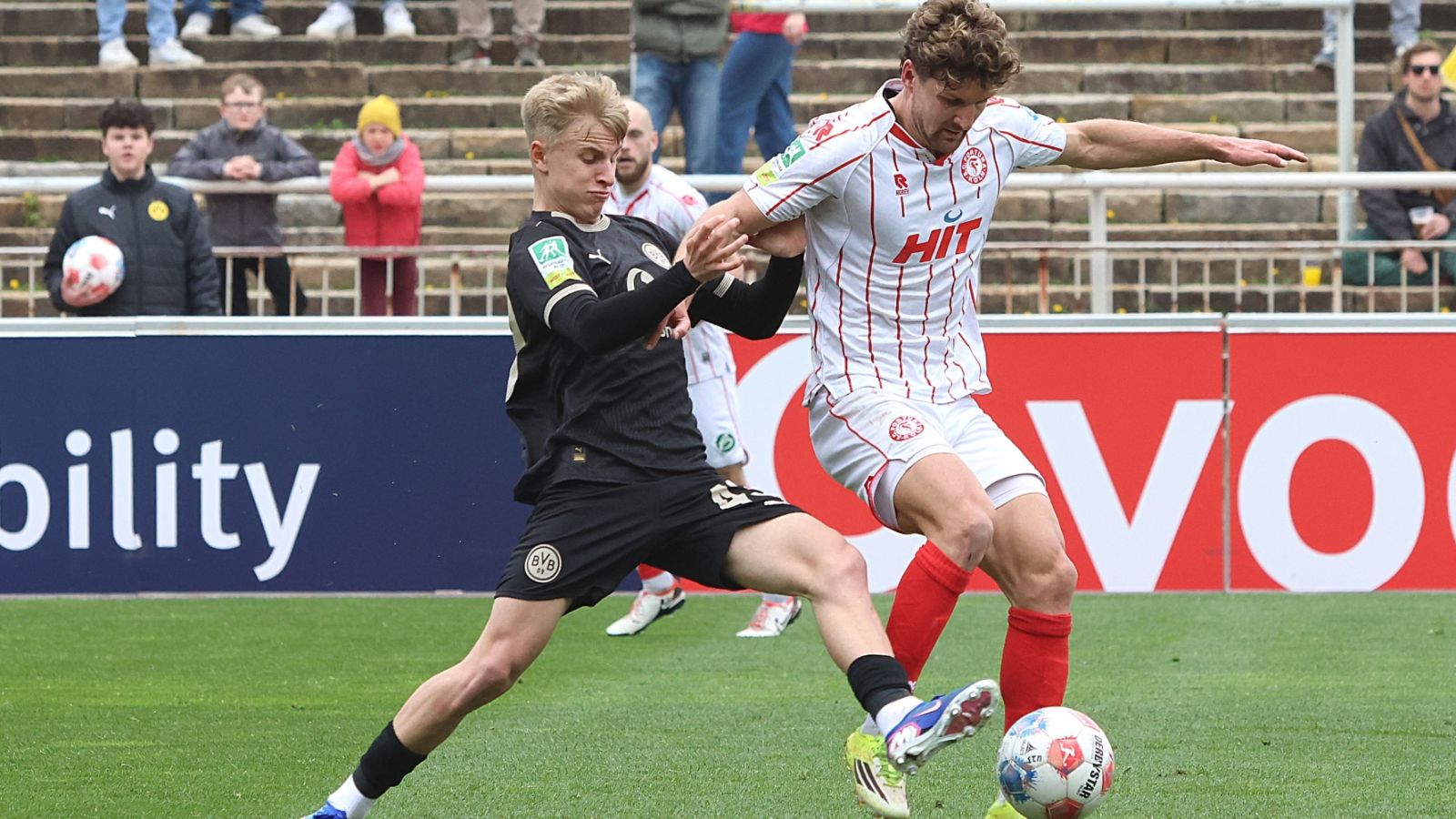 Kölns Torjäger Enzo Wirtz (rechts) behauptet in dieser Szene den Ball gegen BVB-Spieler Danylo Krevsun.
