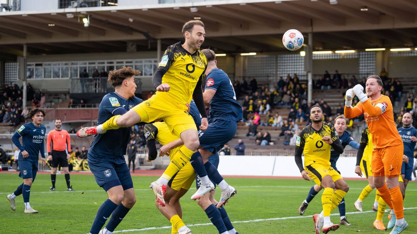 Michael Eberwein, Routinier bei der U 23 von Borussia Dortmund, setzt sich im Luftduell gegen drei Wiedenbrücker Gegenspieler durch.