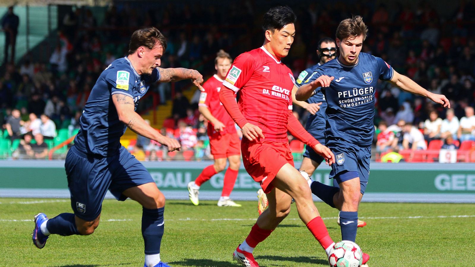 RWO-Angreifer Seok-ju Hong (in der Mitte) behauptet den Ball gegen die Wiedenbrücker Niklas Szeleschus und Joel Udelhoven.