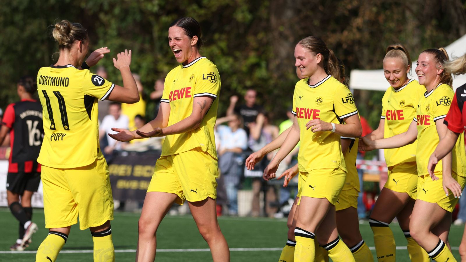 BVB-Kapitänin Alexandra Popp (links) gratuliert Lara Schmidt zu ihrem Treffer beim 5:0-Sieg bei der DJK Südwest Köln.