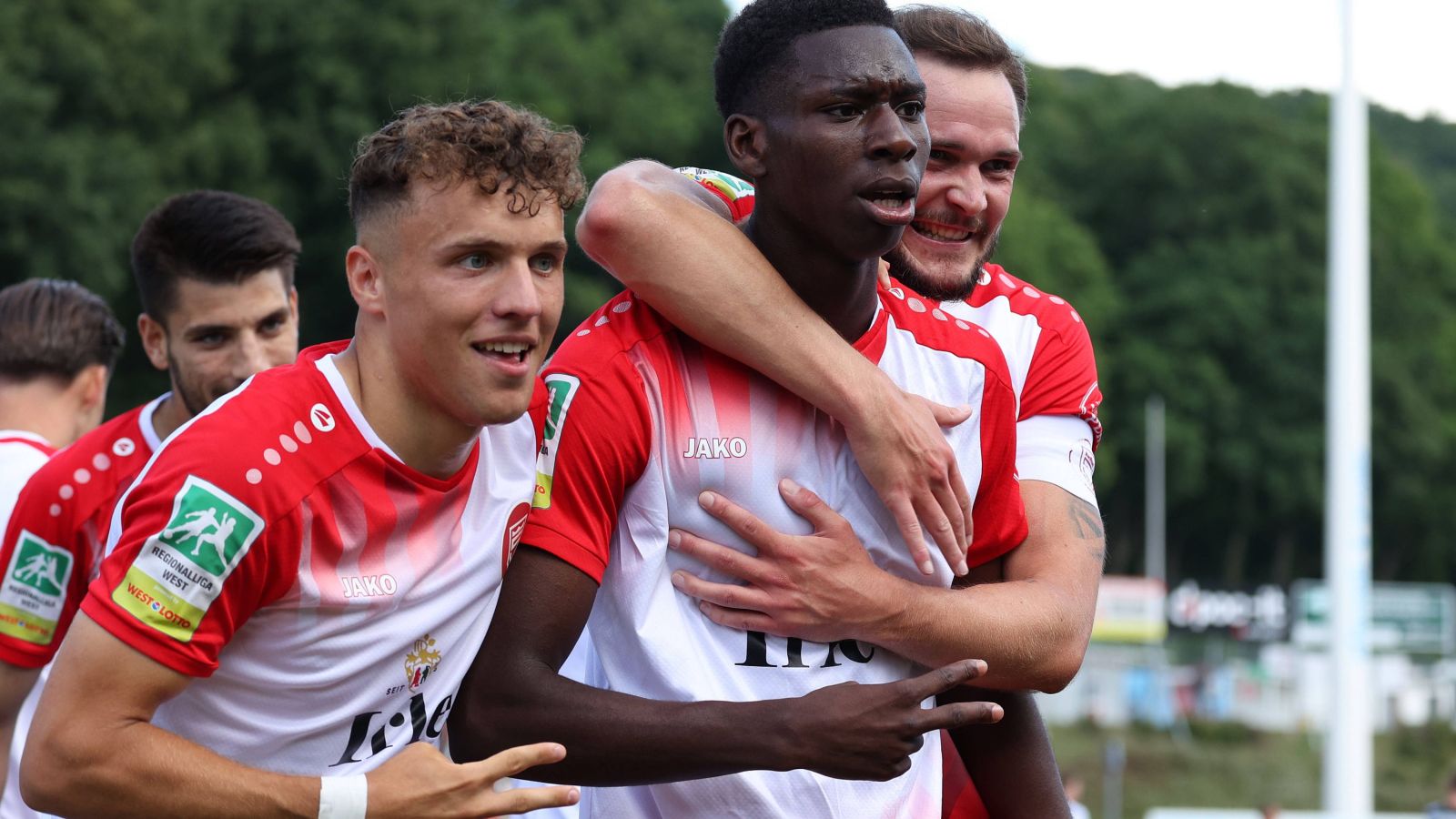 Die beiden Torschützen Malik Hodroj (links) und Josue Santo bejubeln gemeinsam mit Kapitän Florian Mayer (rechts) den 3:0-Auftakterfolg der Sportfreunde Siegen gegen den SV Rödinghausen.